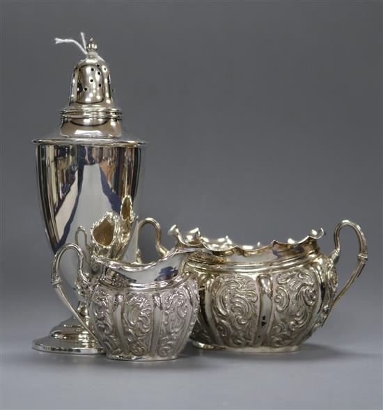 A late Victorian repousse silver sugar bowl and cream jug and a sterling white metal sugar caster.